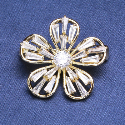 Gold five-petal flower zircon brooch on blue fabric