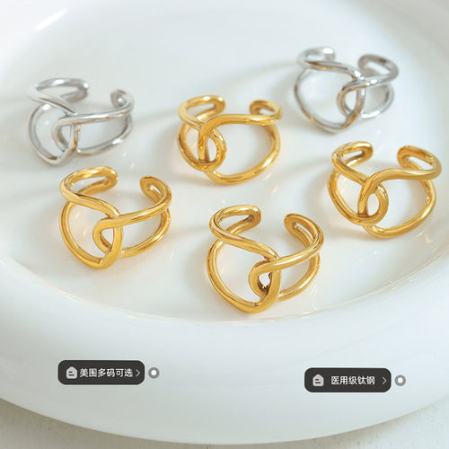 Gold and steel interlocking loop rings arranged on white plate