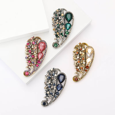 Front view of the openwork crystal leaf brooch with large faceted stones on a white background