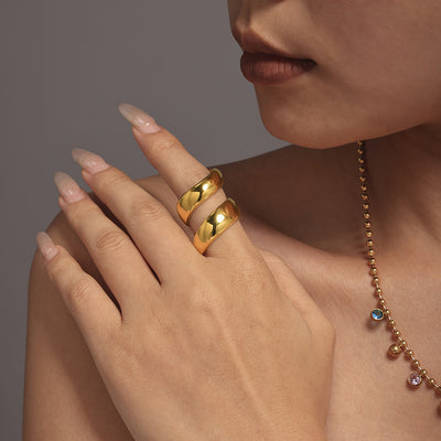 Model wearing gold S-curve spiral wrap ring on index finger