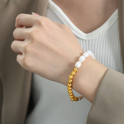 Model wearing gold bead and white pearl stretch bracelet on wrist