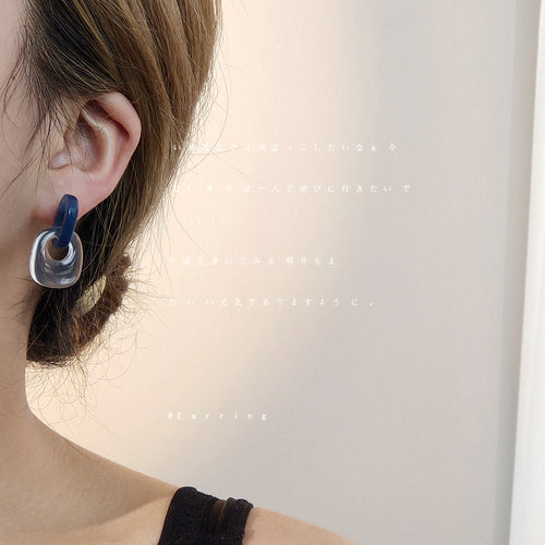 Model wearing blue clear linked acrylic geometric stud on earlobe