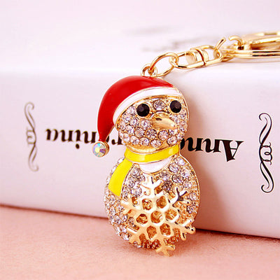 Close-up front view of a rhinestone snowman wearing a red hat and yellow scarf.