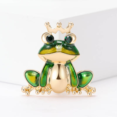 Front view of crowned frog enamel brooch in green and gold decorative metal pin