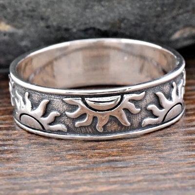 Antique silver sun motif band ring on wood close interior view