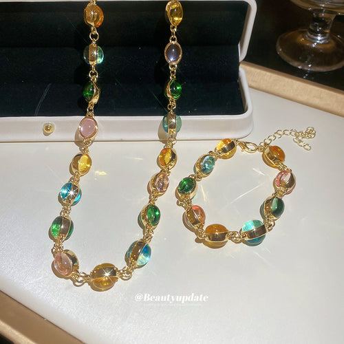 Gold oval multicolor resin necklace and bracelet laid in jewelry box