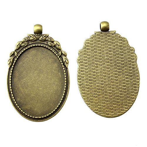 Styled view of ornate oval bezel pendant tray in antique bronze tone