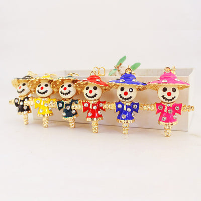 Six gold-tone scarecrow charms in black, yellow, teal, red, blue, and pink.