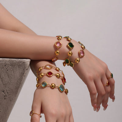 Stack of multicolor cushion glass bead bracelets on wrists