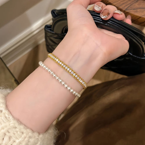Gold double row zircon bracelet worn with pearl stack