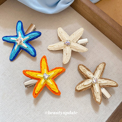 Four raffia starfish duckbill clips on beige fabric drawer