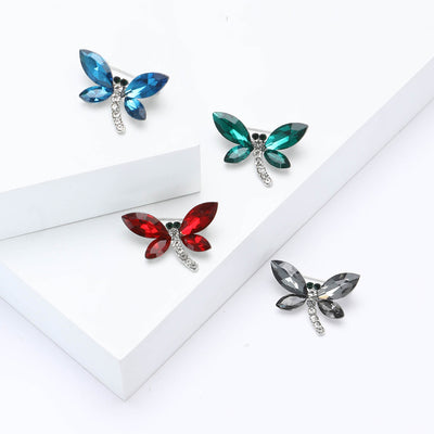 Front view of small dragonfly with faceted colored wings and a curved crystal body
