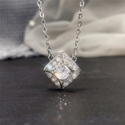 Silver rhombus clear CZ halo pendant necklace close-up on dark surface