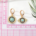 Gold Tone Crystal Turquoise Sun and Evil Eye Huggie Earrings view 2