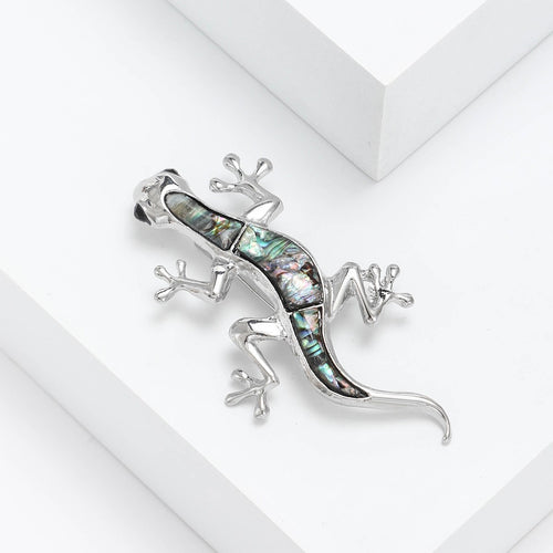 A slender lizard with an iridescent shell inlay shown in a styled display.