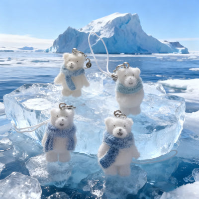 Four flocked polar bear scarf charms on ice block with iceberg backdrop