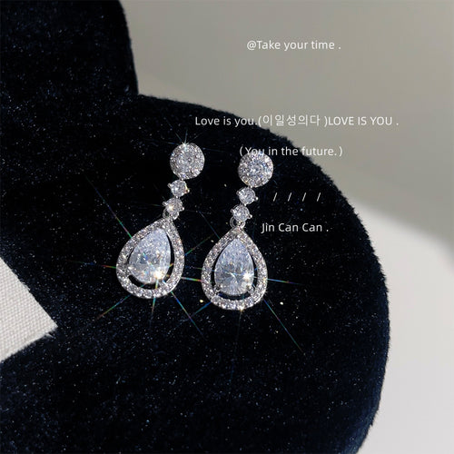 Silver crystal teardrop halo drop earrings on black velvet