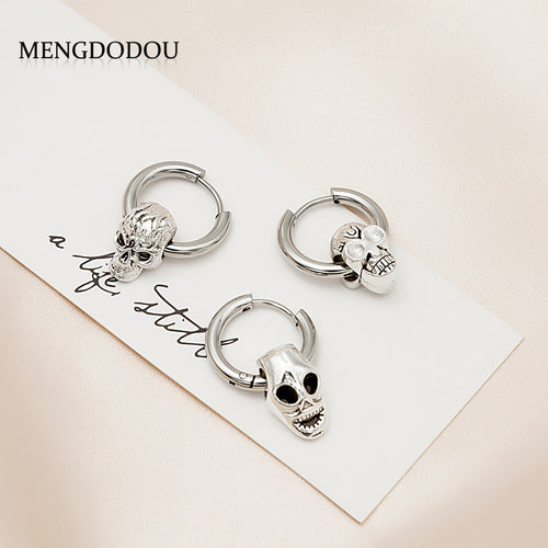 Three silver skull huggie hoop styles on white card with brand text