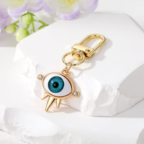 Light blue iris three-spike eye keychain gold lobster clasp close-up