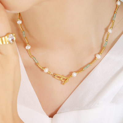 Close-up of pearl green tube necklace with gold OT clasp at front