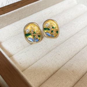 Close-up view of vintage floral pearl and enamel statement earrings assortment