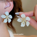 White Textured Flower Stud Earrings with Gold Tone Centers view 1