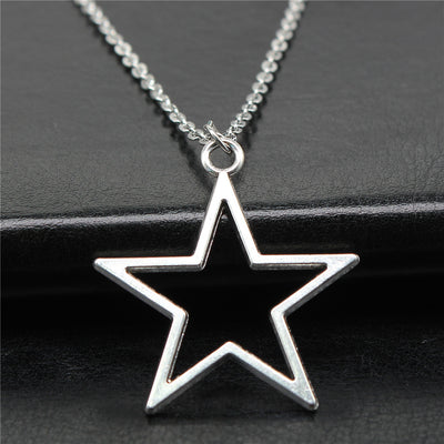 Close view of open star outline pendant necklace in polished silver tone