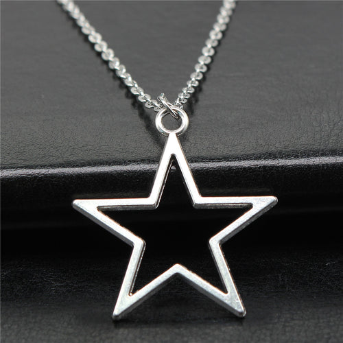 Close view of open star outline pendant necklace in polished silver tone