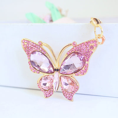 Close-up of a pink butterfly keychain set with pale pink faceted stones and small pink rhinestones.