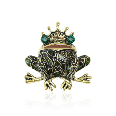 Front view of crowned green mosaic frog brooch with emerald round stones against a white background.