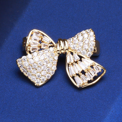 Front view of the crystal bow brooch showing a small gold-tone bow densely set with clear crystals