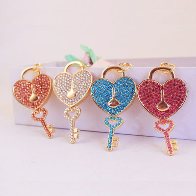 Four rhinestone heart lock and key charms shown in peach, clear, blue, and pink.