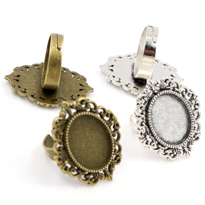 Front overview of ornate oval bezel ring settings in silver and bronze tones arranged on a light background