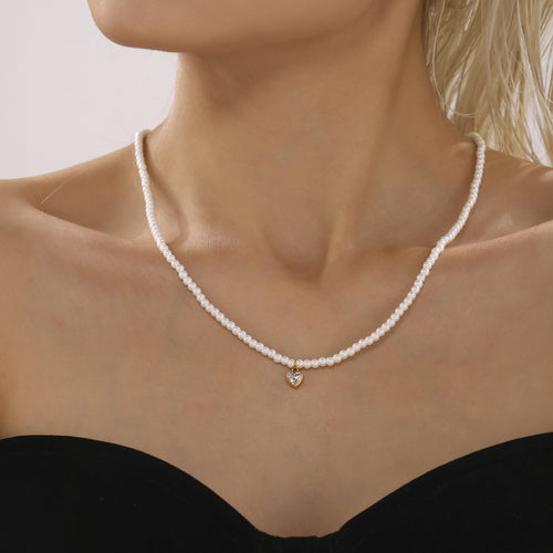 White shell pearl choker with gold heart zircon pendant worn on model