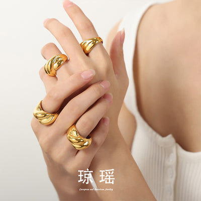 Hands stacked with multiple gold twisted plump band rings