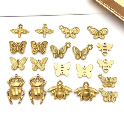Gold-tone bee and butterfly charms arranged on a light background