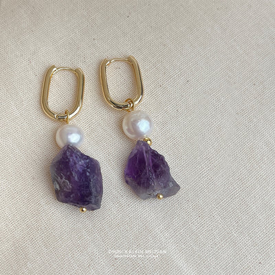 Gold oval huggie pearl raw amethyst drops on beige linen