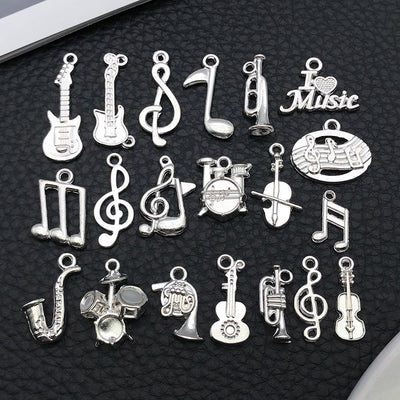 Black musical instrument and guitar charms arranged on a light background