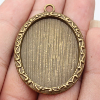 Front view of oval beaded edge cabochon pendant setting on fingertips