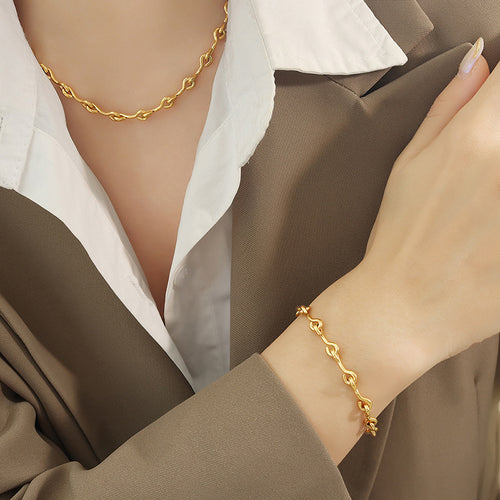 Gold U-link necklace and bracelet worn together on model