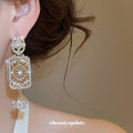 Gold Tone Crystal Rectangle Drop Earrings With Polished Metal Details view 3