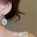 Blue Round Stone Drop Earrings with White Halo and Gold Tone Hooks view 3