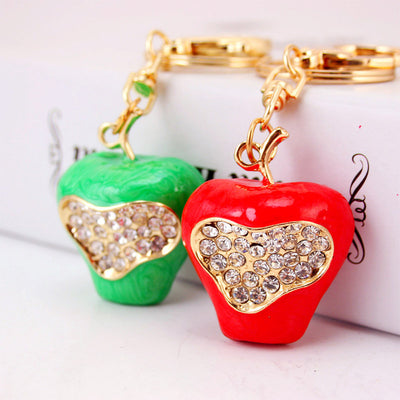 Red and green apple keychains with clear faceted accents displayed together.