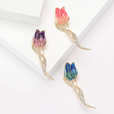 Green Tulip, Purple Tulip, Pink Tulip brooch styles arranged on a light display