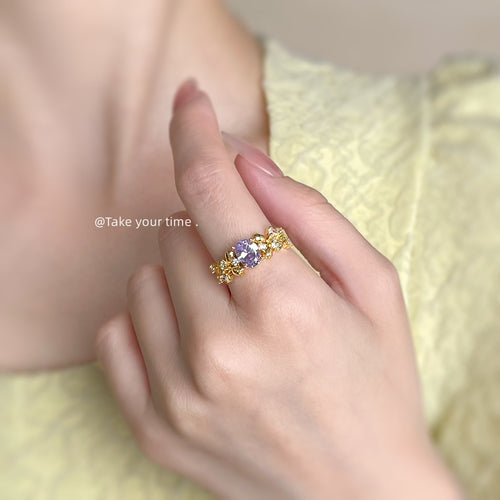 Gold purple oval crystal leaf ring worn on index finger
