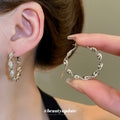 Gold Tone Twisted Hoop Earrings With Leaf Shaped Links view 3