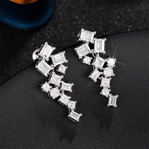 Side view of silver tone geometric crystal cluster drop earrings
