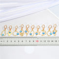 Gold Tone Evil Eye Huggie Earrings with Ten Symbolic Drop Designs view 2