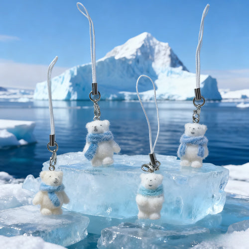 Four polar bear phone charms hanging against arctic ice landscape