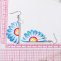 Silver Tone Daisy Acrylic Hook Earrings in Yellow and Blue view 3